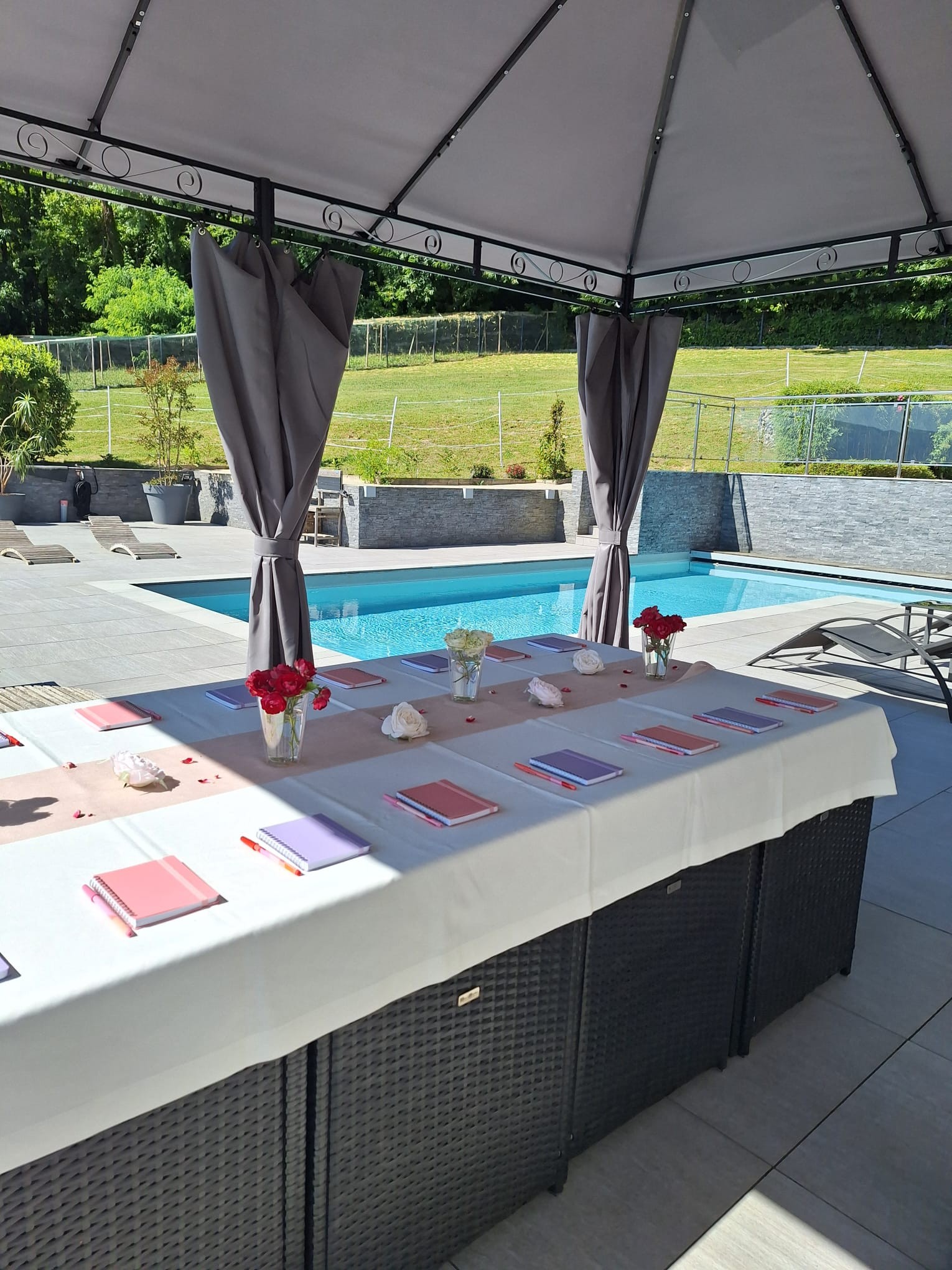 Table de réunion installée au bord de la piscine de la Villa Gai Moulin à Rumilly