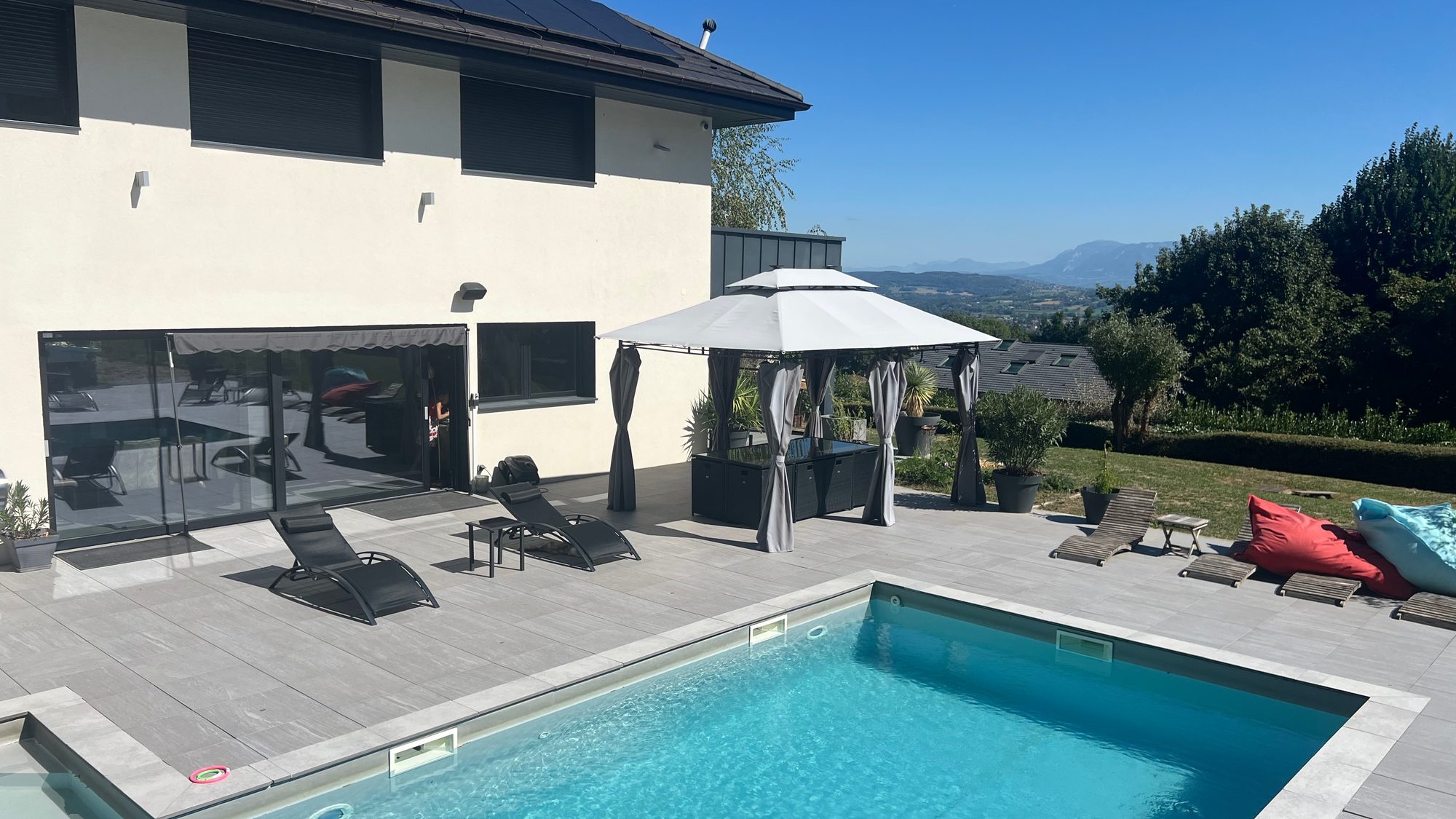 Terrasse et transats au bord de la piscine de la Villa Gai Moulin